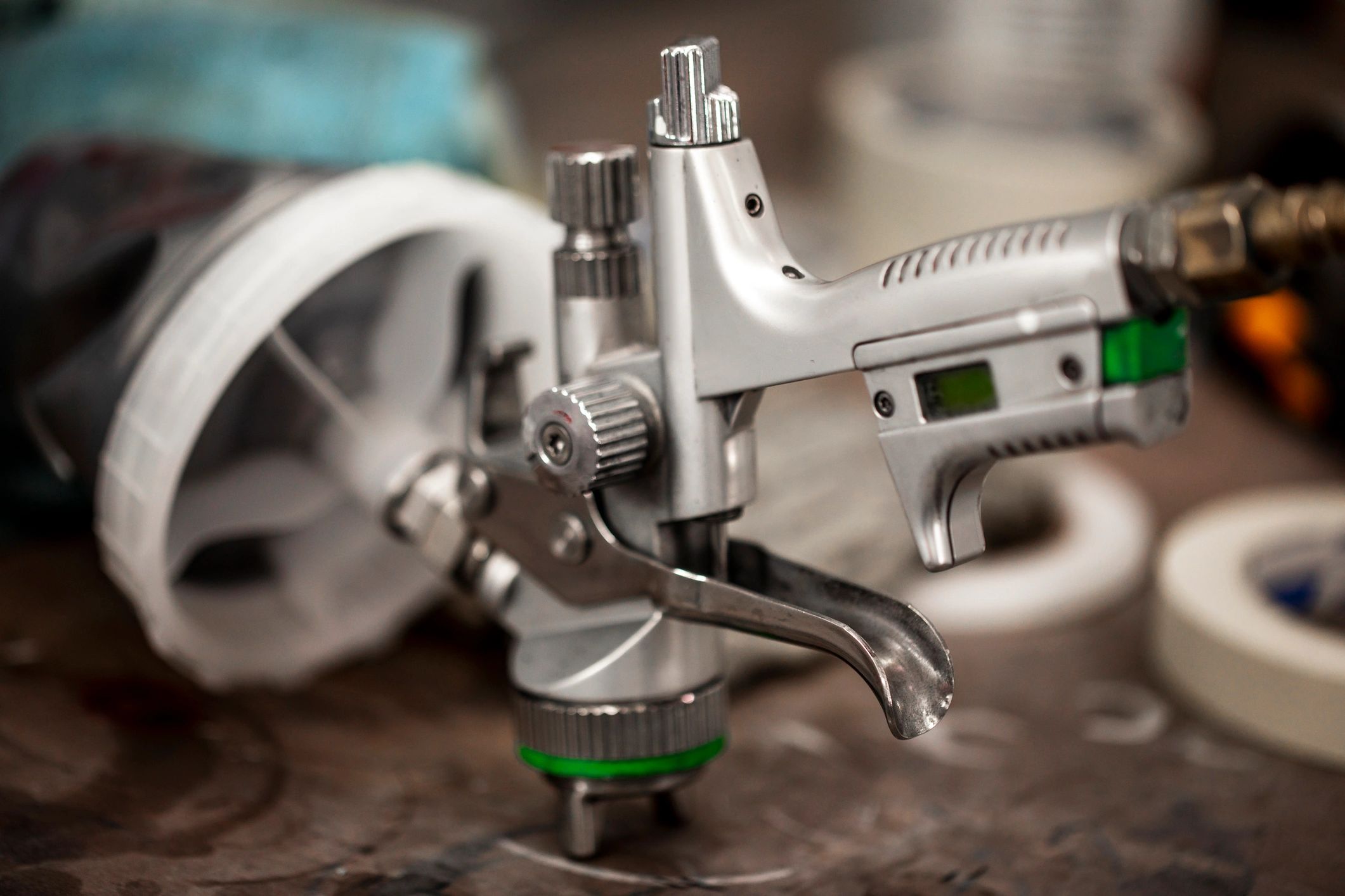 Spray gun resting on a workshop bench